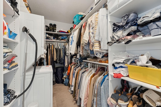 spacious closet with light carpet and washer / dryer