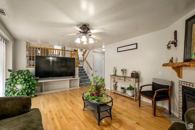 1426 N Quincy Ave, Ogden, UT 84404 - living room featuring a fireplace with flush hearth, stairway, a ceiling fan, light wood-style floors, and baseboards