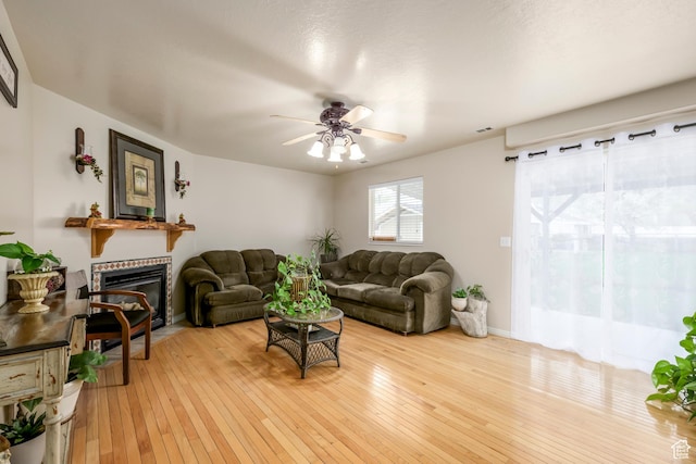 1426 N Quincy Ave, Ogden, UT 84404 - living area with light wood-style flooring, visible vents, baseboards, a glass covered fireplace, and ceiling fan