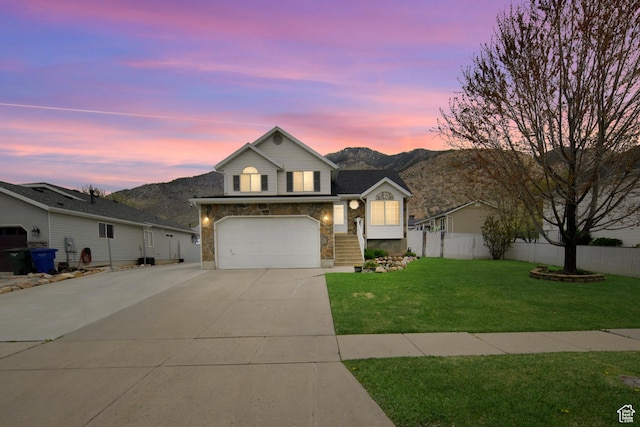 1426 N Quincy Ave, Ogden, UT 84404 - view of front of house featuring stone siding, driveway, fence, and a garage
