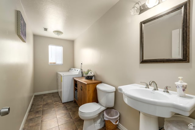 1426 N Quincy Ave, Ogden, UT 84404 - bathroom featuring a sink, baseboards, toilet, washer / clothes dryer, and visible vents