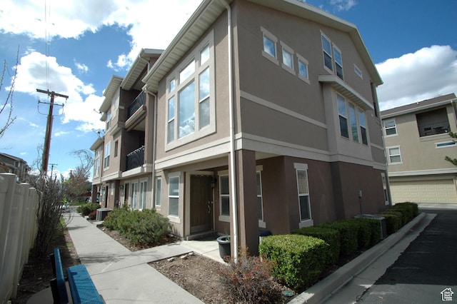 view of home's exterior featuring central air condition unit, stucco siding, and fence