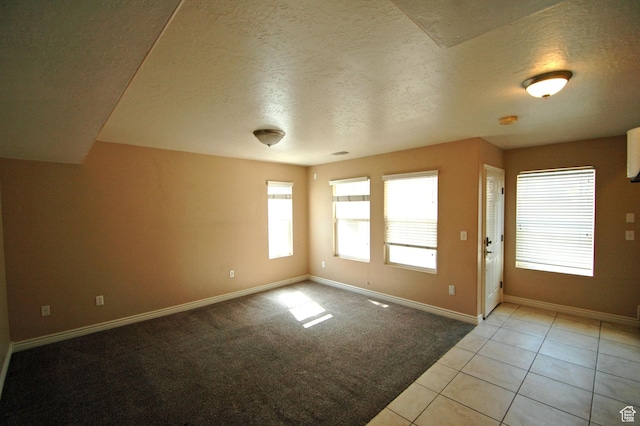 interior space with baseboards, light colored carpet, light tile patterned floors, and a textured ceiling