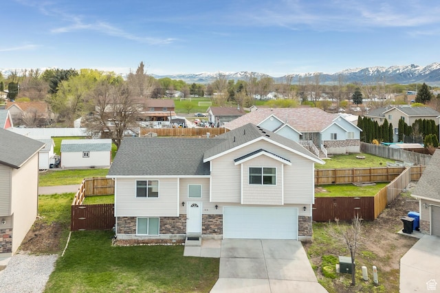 818 W 530 S, Logan, UT 84321 - view of front of house with stone siding, an attached garage, a residential view, driveway, and a mountain view