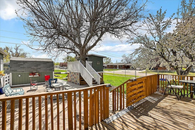 wooden deck featuring an outbuilding, a storage shed, and stairs