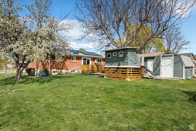 view of yard featuring a wooden deck, an outbuilding, and a shed