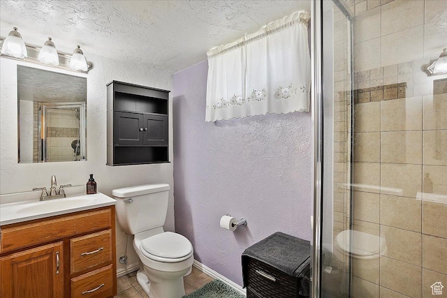 full bathroom with a shower stall, toilet, vanity, baseboards, and a textured ceiling