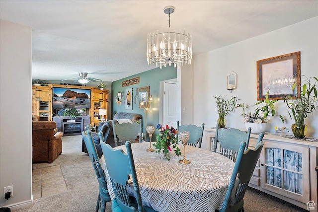 dining area featuring carpet and ceiling fan with notable chandelier