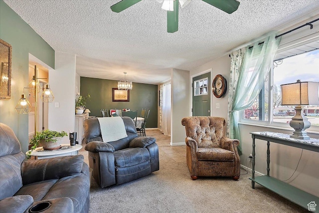 carpeted living area with plenty of natural light, a textured ceiling, and ceiling fan with notable chandelier