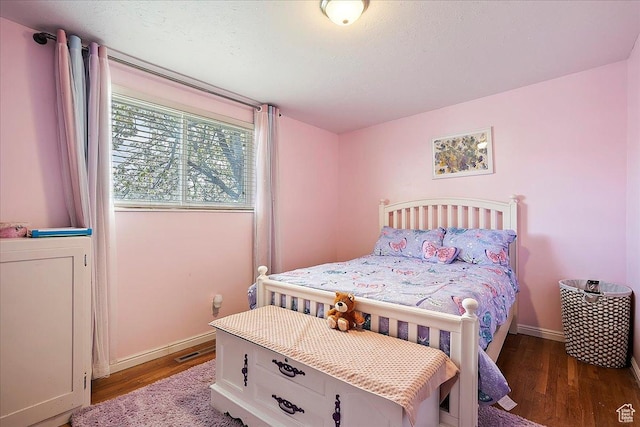 bedroom featuring baseboards and wood finished floors