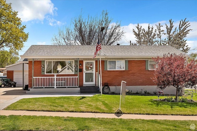 single story home with brick siding, a garage, a front yard, and covered porch