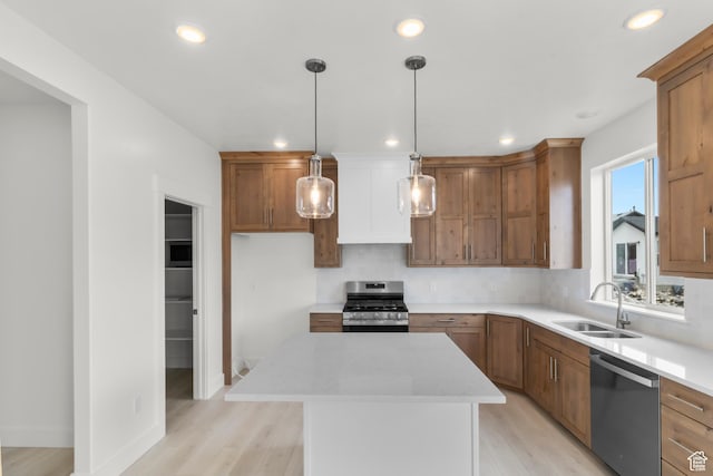 556 N 800 W, Smithfield, UT 84335 - kitchen with brown cabinets, a sink, light wood-style floors, a center island, and appliances with stainless steel finishes