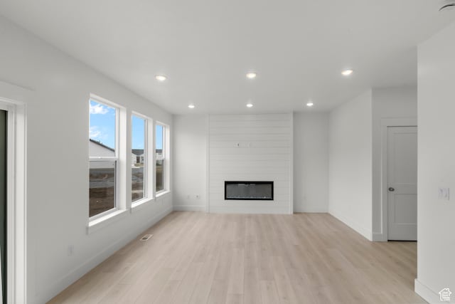556 N 800 W, Smithfield, UT 84335 - unfurnished living room featuring light wood-type flooring, a large fireplace, baseboards, visible vents, and recessed lighting