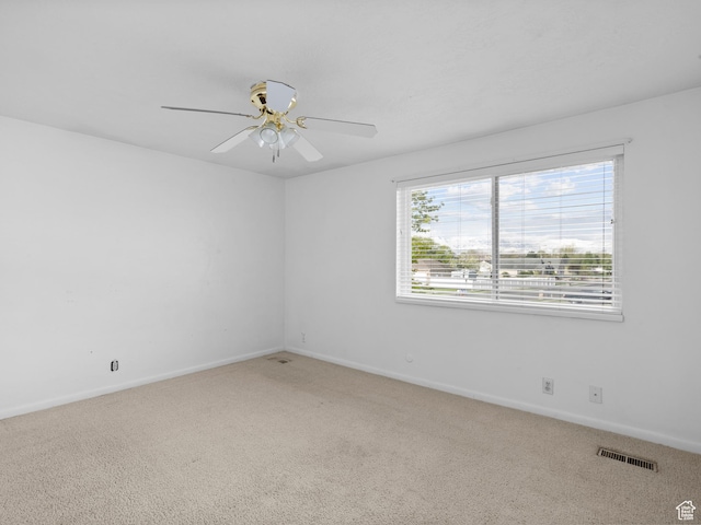 carpeted empty room with ceiling fan, baseboards, and visible vents