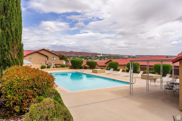 pool with fence, a patio area, and a mountain view