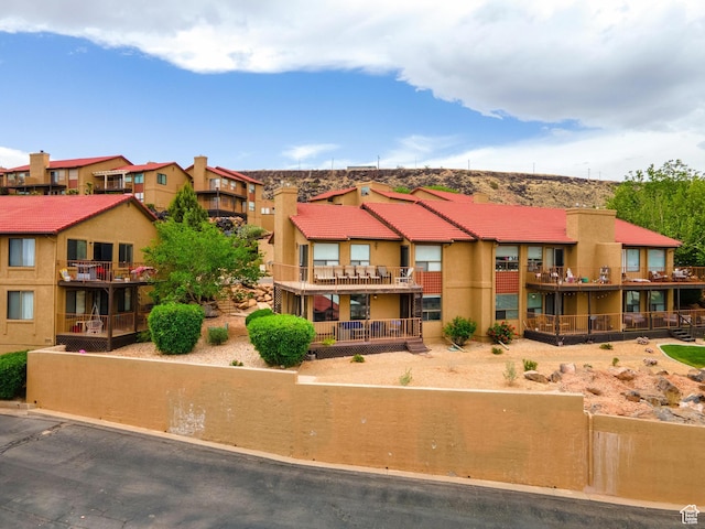 view of front of house with stucco siding, a tile roof, and a residential view