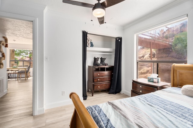 bedroom with ceiling fan, baseboards, ornamental molding, and light wood-style floors