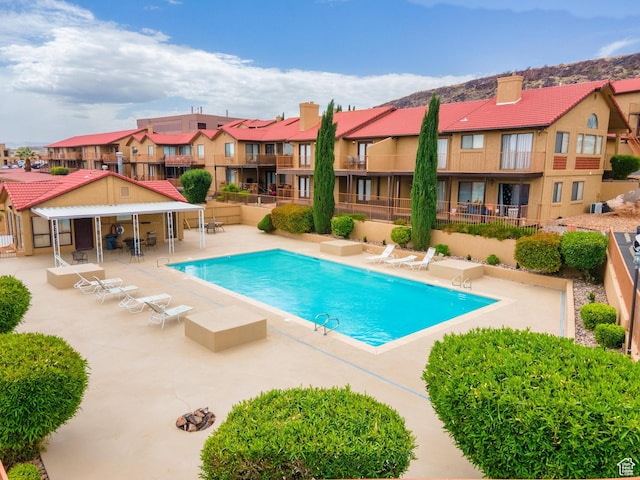 pool featuring a patio area, fence, and a residential view