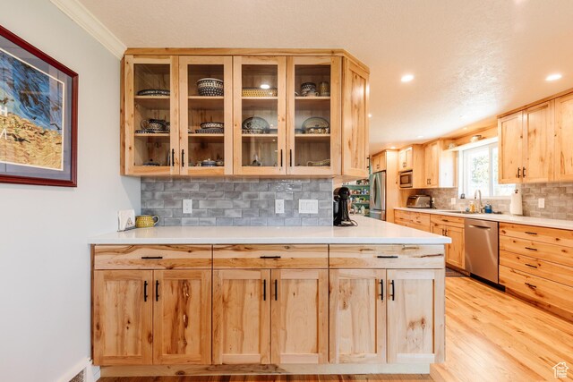 1550 E 2100 N, North Logan, UT 84341 - kitchen with light wood finished floors, stainless steel appliances, light countertops, light brown cabinets, and decorative backsplash