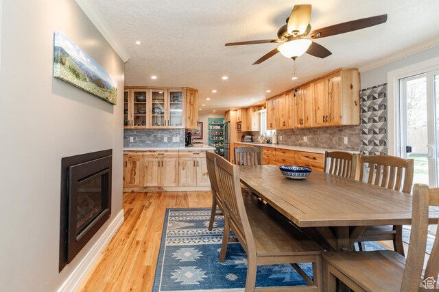 1550 E 2100 N, North Logan, UT 84341 - dining space with recessed lighting, light wood-style floors, crown molding, a glass covered fireplace, and ceiling fan