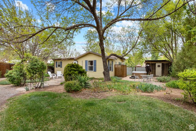 168 S 100 W, Moab, UT 84532 - rear view of house with a storage shed, a lawn, fence, an outbuilding, and a patio