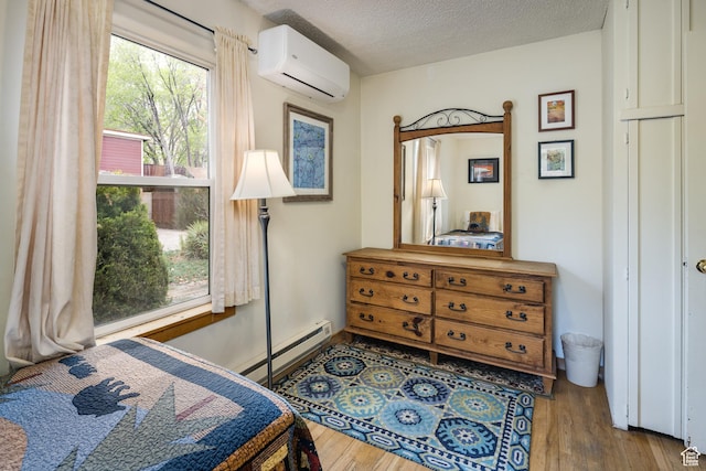 168 S 100 W, Moab, UT 84532 - bedroom featuring a wall mounted AC, wood finished floors, a textured ceiling, and baseboard heating