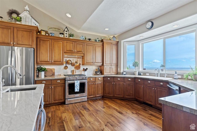 kitchen featuring a sink, appliances with stainless steel finishes, and brown cabinets