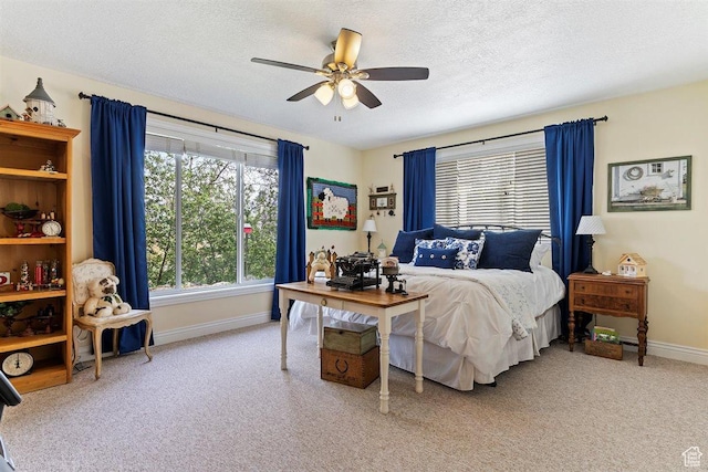 carpeted bedroom featuring a textured ceiling, baseboards, and a ceiling fan