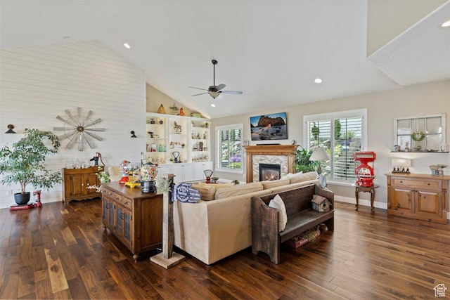 living area featuring a ceiling fan, a stone fireplace, dark wood finished floors, high vaulted ceiling, and recessed lighting
