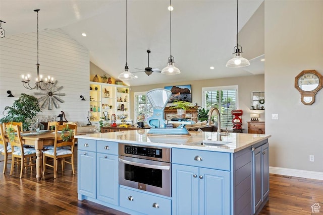 kitchen with a kitchen island with sink, dark wood-style flooring, a sink, a chandelier, and oven