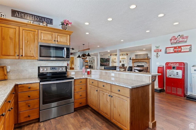 kitchen featuring dark wood-style flooring, appliances with stainless steel finishes, a textured ceiling, a peninsula, and open floor plan