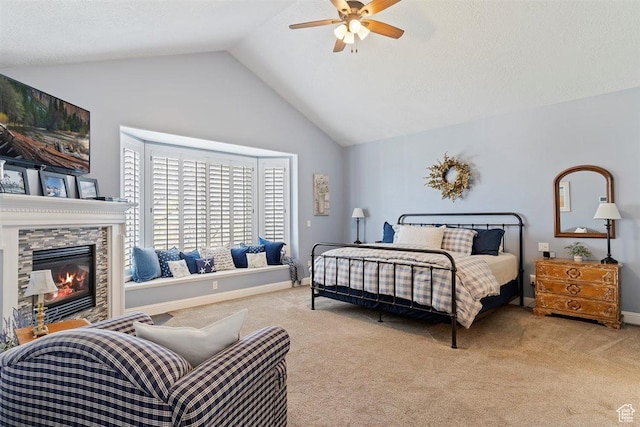 carpeted bedroom with a tiled fireplace, a ceiling fan, baseboards, and high vaulted ceiling