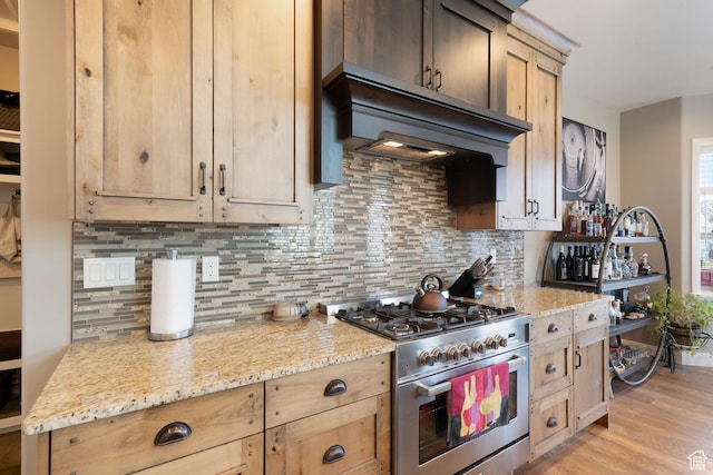 4423 Ranch Blvd, Mountain Green, UT 84050 - kitchen featuring high end stove, custom exhaust hood, backsplash, and light wood finished floors