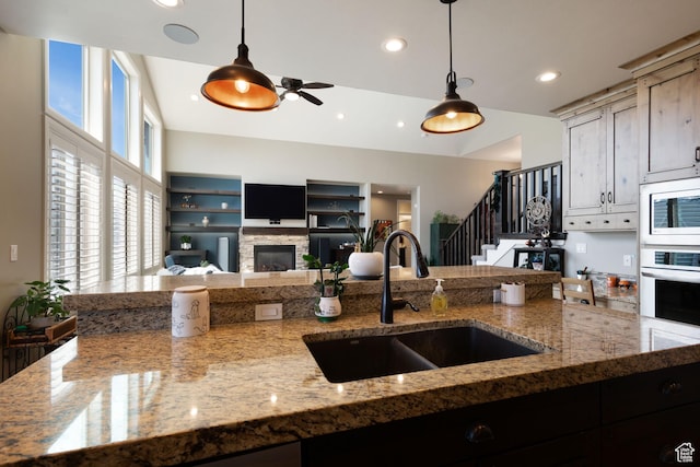 4423 Ranch Blvd, Mountain Green, UT 84050 - kitchen with a sink, built in microwave, pendant lighting, white oven, and a stone fireplace