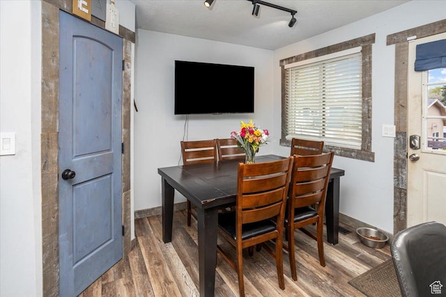 dining area with baseboards and wood finished floors