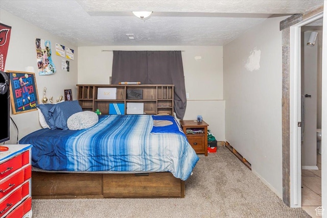 carpeted bedroom with baseboards and a textured ceiling