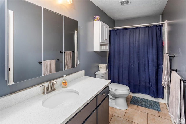 bathroom with tile patterned floors, a textured ceiling, vanity, toilet, and visible vents