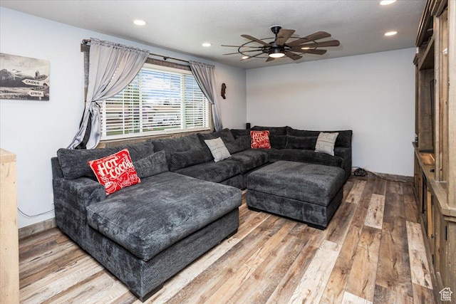 living room featuring hardwood / wood-style flooring, a ceiling fan, and recessed lighting