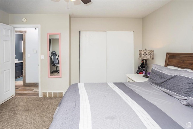 bedroom with a ceiling fan, visible vents, carpet, and a closet