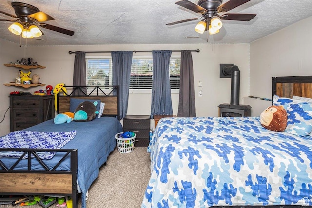 carpeted bedroom with a ceiling fan, a wood stove, and a textured ceiling