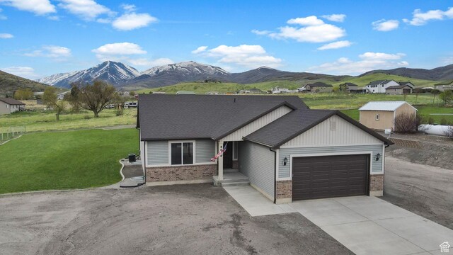 8050 W 1900 N, Petersboro, UT 84325 - ranch-style home with a mountain view, an attached garage, concrete driveway, and brick siding