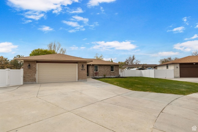 ranch-style house featuring a gate, a front lawn, driveway, brick siding, and a garage