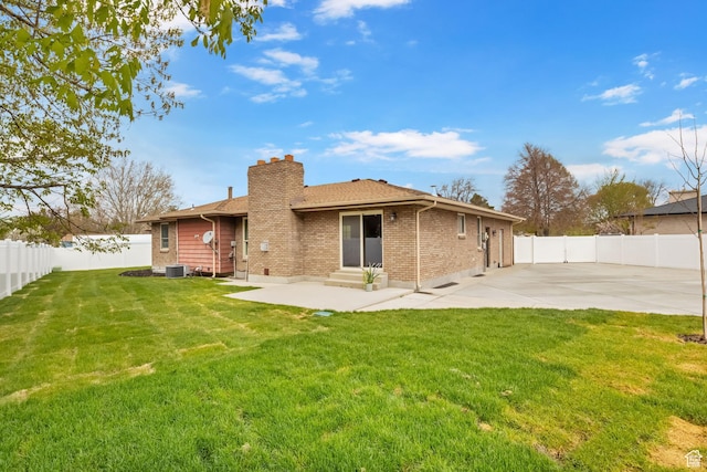 rear view of property with a chimney, a fenced backyard, entry steps, a patio area, and brick siding