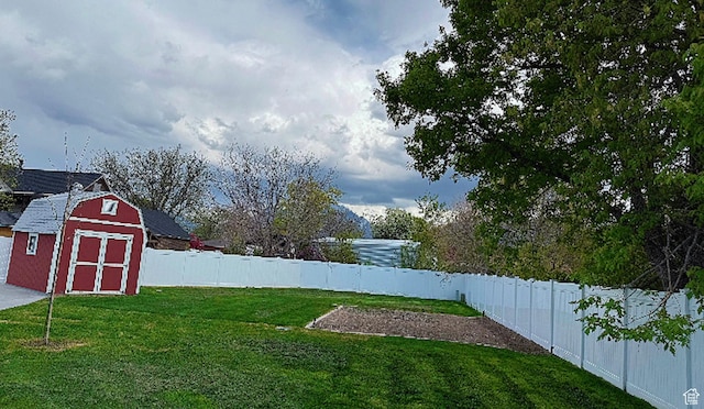 view of yard featuring a fenced backyard, an outdoor structure, and a storage shed