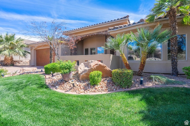 view of home's exterior featuring stucco siding, a tile roof, a lawn, and a garage