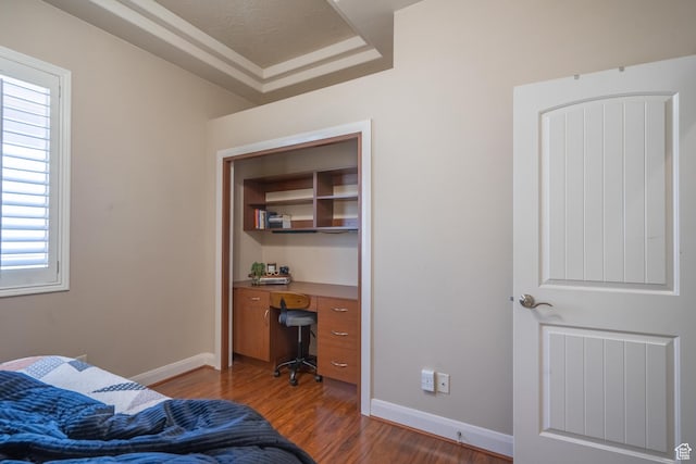 bedroom with multiple windows, dark wood-style flooring, a desk, and baseboards