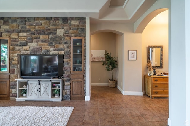 tiled living area with arched walkways and baseboards