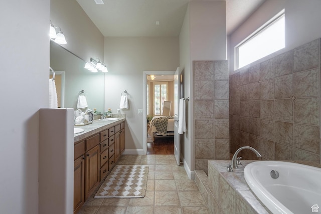 bathroom featuring a bath, double vanity, and ensuite bathroom