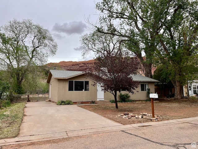 736 Westwood Ave, Moab, UT 84532 - view of front of home featuring concrete driveway, roof with shingles, entry steps, and stucco siding