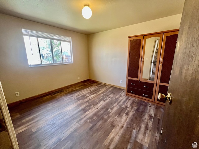 736 Westwood Ave, Moab, UT 84532 - unfurnished bedroom featuring baseboards, dark wood-type flooring, and a closet